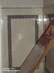 Part of the shower wall with a broken door Part of the shower wall with a broken door